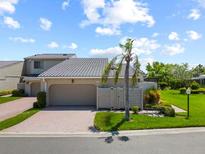 Charming home with a two-car garage, lush landscaping, and a well-manicured lawn at 2181 Harbourside Dr # 1403, Longboat Key, FL 34228