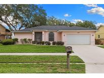Charming single-story home featuring a well-manicured lawn and attached two-car garage at 2559 Wood Oak Dr, Sarasota, FL 34232