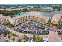 A lovely aerial view of the condominium complex with a large parking lot and lake in the background at 3635 Lake Bayshore Dr # J-410, Bradenton, FL 34205