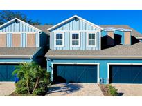Charming blue townhome with a two-car garage and well-maintained landscaping at 4532 Chinkapin Dr, Sarasota, FL 34232