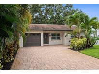Charming single-story home with a well-maintained brick driveway and lush tropical landscaping at 5702 Tangerine S Ave, Gulfport, FL 33707