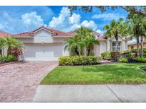 Charming single-story home featuring a lush lawn, red tile roof and a brick driveway at 6312 41St E Ct, Sarasota, FL 34243