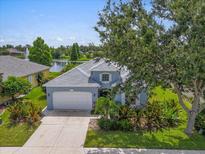 Inviting home featuring lush landscaping, a two-car garage, and a peaceful lake view at 7026 43Rd E Ave, Palmetto, FL 34221