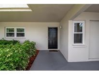 Front door and windows surrounded by lush, verdant bushes creates an inviting entrance to this lovely home at 7301 W. Country Club N Dr # 108, Sarasota, FL 34243