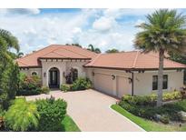 Well-maintained, charming one-story home featuring a tile roof, beautiful landscaping, and a brick driveway at 7605 Haddington Cv, Lakewood Ranch, FL 34202