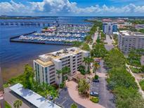 Stunning aerial view of waterfront condo near marina, featuring lush landscaping and beautiful city views at 1510 1St W Ave # 102, Bradenton, FL 34205