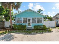 Charming, light blue single-story home with ample windows and a well-maintained front yard and a palm tree at 1911 26Th W St, Bradenton, FL 34205