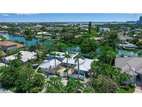 Stunning aerial view of waterfront home with lush landscaping and access to the bay at 259 S Polk Dr, Sarasota, FL 34236