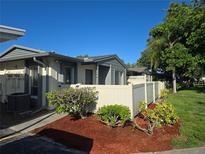 Charming exterior view of a well-maintained property, featuring a freshly mulched garden area and a light beige privacy fence at 2606 29Th Ave W # 12, Bradenton, FL 34205