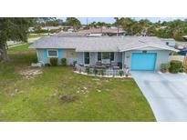 Charming single-story home with a well-manicured lawn, a bright blue garage door, and inviting front patio at 453 Sandlewood Dr, Venice, FL 34293
