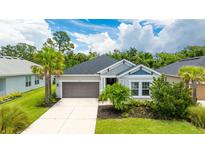 Charming single-story home featuring a two-car garage, well-manicured lawn, and mature landscaping at 5927 Maidenstone Way, Palmetto, FL 34221