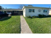 Charming single-story home with a well-manicured lawn and a covered front patio at 6048 Merril St, North Port, FL 34287