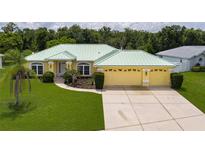 Charming single-story home featuring a lush green lawn and a spacious two-car garage at 6114 68Th E Dr, Palmetto, FL 34221