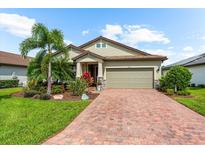 Charming single-story home featuring a lush, landscaped yard and a brick-paved driveway at 6854 Chester Trl, Lakewood Ranch, FL 34202