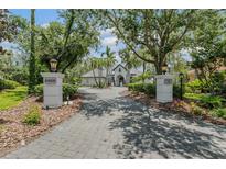 Beautiful home exterior with a long driveway, mature trees, and meticulous landscaping at 6959 Westchester Cir, Bradenton, FL 34202