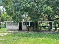 Charming single-story home featuring mature trees and a screened-in porch for outdoor enjoyment at 9344 Peony St, New Port Richey, FL 34654