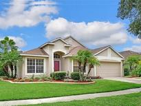 Charming single-story home with a well-manicured lawn, mature landscaping, and an attached two-car garage at 9406 Sarazen Pl, Palmetto, FL 34221