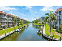 Beautiful waterfront condominiums with boat docks, surrounded by lush landscaping and blue skies at 1257 S Portofino Dr # 306, Sarasota, FL 34242