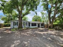 Charming single-story home with mature trees and a screened-in porch, offering a tranquil setting at 27 Tucker Ave, Sarasota, FL 34232