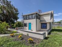 Stylish home with a bright blue door and front patio surrounded by lush landscaping and flowerbeds at 305 Chauncey Ave, Bradenton, FL 34208