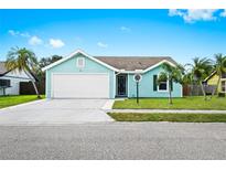 Charming aqua home with well-kept lawn, large driveway, and a two-car garage at 3551 65Th Avenue E Cir, Sarasota, FL 34243