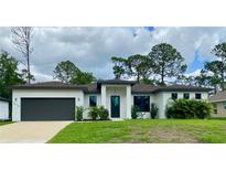 Stunning single-story home featuring a modern design, lush landscaping, and a spacious two-car garage at 3616 Bellefonte Ave, North Port, FL 34286