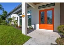 Inviting front entrance featuring a vibrant orange double door and well-maintained landscaping at 3636 Mineola, Sarasota, FL 34239