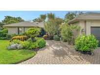 Charming home features a lush, landscaped front yard and a brick driveway at 4761 Pine Harrier Dr, Sarasota, FL 34231