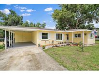 Charming single-story home with yellow siding, white shutters, and a well-manicured lawn and landscaping at 5350 Barbarossa Ave, Sarasota, FL 34235