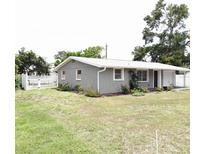 Charming gray home featuring a well-maintained lawn, fenced yard, and covered parking at 611 Missouri Rd, Venice, FL 34293