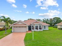 Charming single-story home boasts a red tile roof, lush landscaping, and a spacious two-car garage at 7115 39Th E Ln, Sarasota, FL 34243