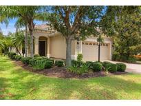 Charming single-story home with a well-manicured lawn and tropical landscaping at 7130 Westhill Ct, Lakewood Ranch, FL 34202