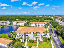 Beautiful exterior of a condominium building with lush landscaping and a peaceful lake view at 1000 San Lino Cir # 1032, Venice, FL 34292