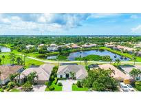Stunning aerial view of a luxurious home on a pond overlooking a golf course community at 1017 Tuscany Blvd, Venice, FL 34292