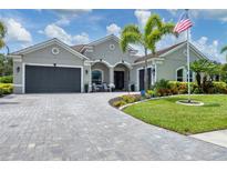 Beautiful single-story home features a three-car garage and a well-manicured lawn with vibrant landscaping at 16038 39Th E Gln, Parrish, FL 34219