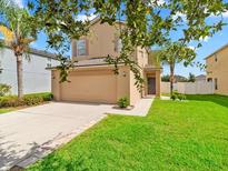 Two-story home with manicured lawn, neutral colored exterior, and a two car garage at 2118 Song Sparrow Ct, Ruskin, FL 33570
