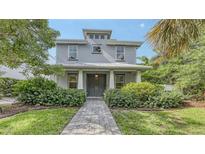 Charming two-story home features a well-manicured lawn and lush landscaping at 2410 Prospect St, Sarasota, FL 34239