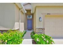 Charming home featuring a stone accent wall and a beautiful, colorful front door entrance at 2450 Dovesong Trace Dr, Ruskin, FL 33570