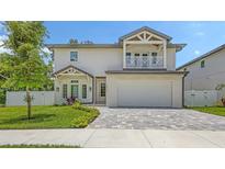 Charming two-story home featuring a second story balcony, attached garage and well-manicured lawn at 2596 Floyd St, Sarasota, FL 34239