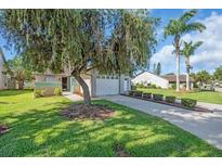 Charming single-story home with lush landscaping, mature tree, and a well-maintained lawn at 327 40Th W Ct, Palmetto, FL 34221