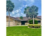 Inviting single-story home featuring lush landscaping, stone accents, and mature palm trees at 3764 Torrey Pines Blvd, Sarasota, FL 34238