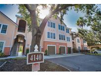 Attractive condo building with garages and inviting exterior features and verdant trees at 4140 Central Sarasota Pkwy # 1235, Sarasota, FL 34238