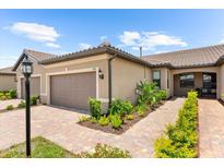 Charming home featuring well-maintained landscaping, a tile roof, and a two-car garage at 7661 Summerland Cv, Bradenton, FL 34202