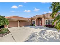 Beautiful home featuring a tile roof, three-car garage and a well-manicured front yard at 8445 Lone Eagle Way, Sarasota, FL 34241