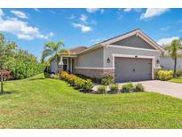 Charming single-story home with manicured lawn, stone accents, and a two-car garage at 8641 Rain Song Rd, Sarasota, FL 34238