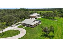 Stunning property featuring a sprawling lawn, main house, and separate large garage/workshop building at 920 Lena Ln, Sarasota, FL 34240