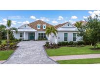 Inviting single-Gathering home boasting lush landscaping and a charming light-blue exterior at 16511 Cornwall Ln, Lakewood Ranch, FL 34202