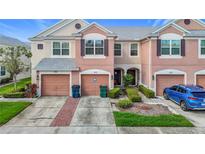 Charming townhome showcasing a two-car garage, well-manicured landscaping, and inviting curb appeal at 26548 Castleview Way, Wesley Chapel, FL 33544