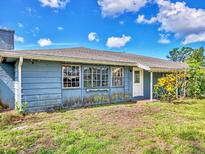 Quaint home exterior featuring a chimney, large windows, and front door with green space at 2818 Olympic St, Sarasota, FL 34231