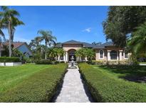Elegant home featuring lush landscaping, a brick walkway, a fountain, and charming architectural details at 2962 Wilderness E Blvd, Parrish, FL 34219